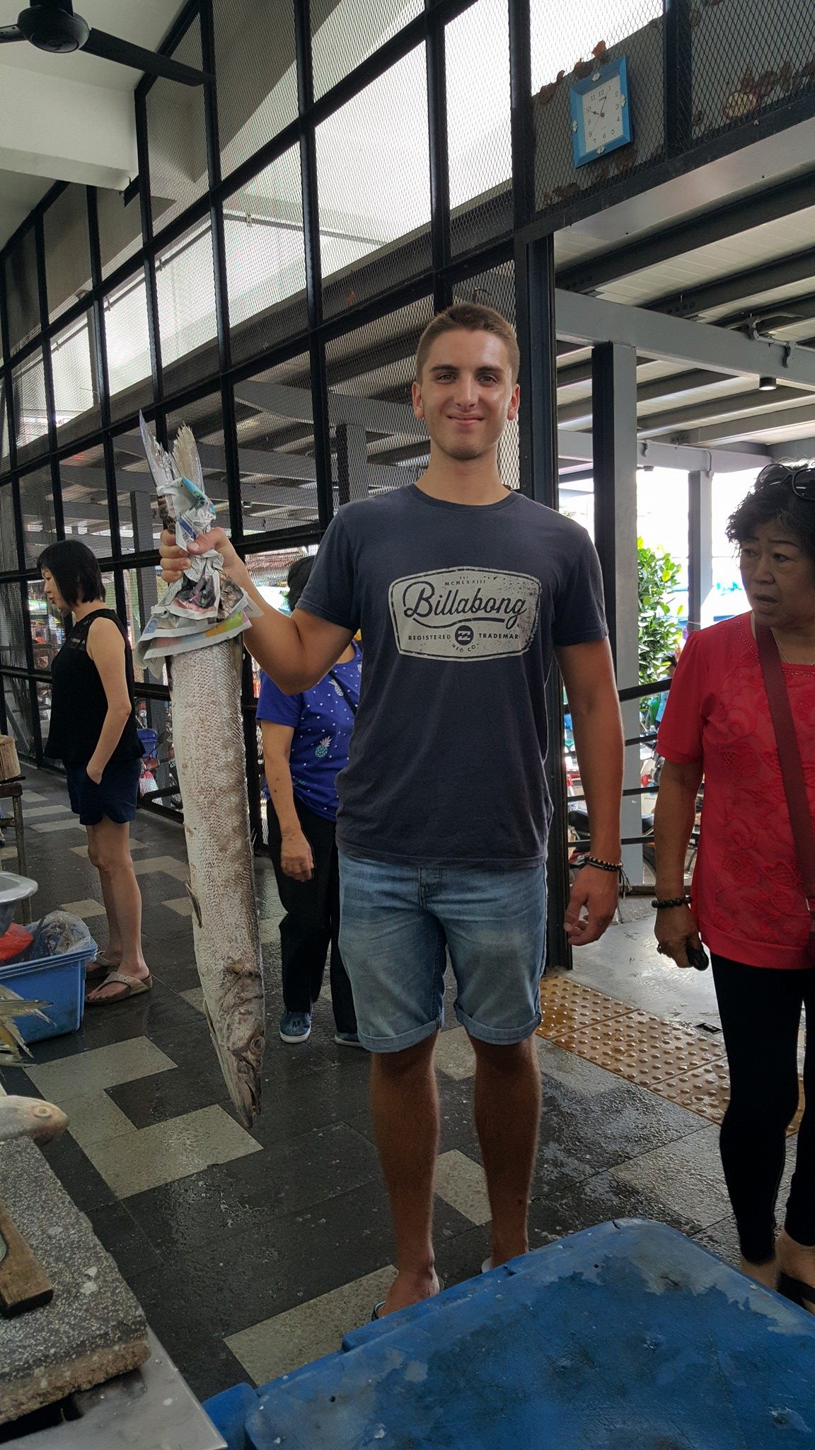 holding fish at the market